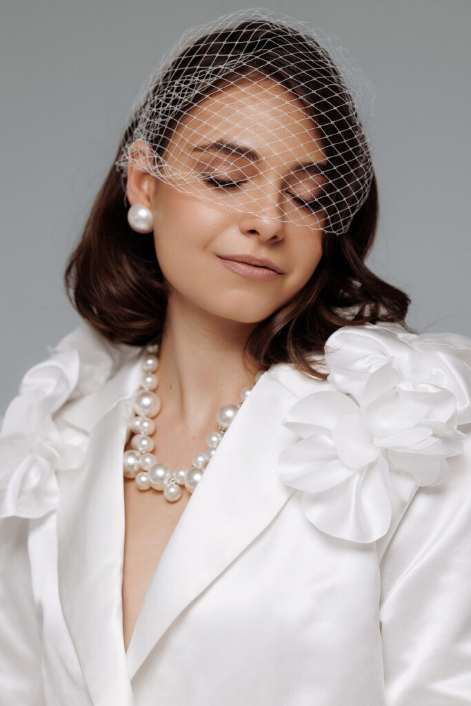 Γυναίκα με λευκό φόρεμα και μαργαριταρένιο κολιέ.