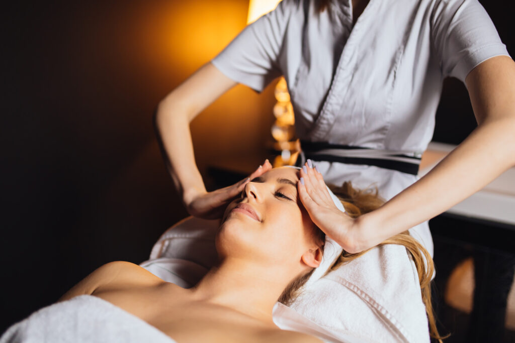 Όμορφη νεαρή γυναίκα που απολαμβάνει μασάζ και αναζωογονείται