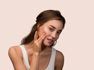 Ομορφη καστανή γυναίκα ακουμπαέι το χέρι της στο καθαρό υγιές πρόσωπό της